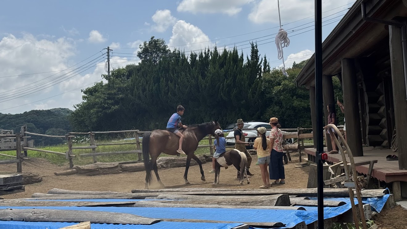 The kids riding horses with guides at a countryside ranch