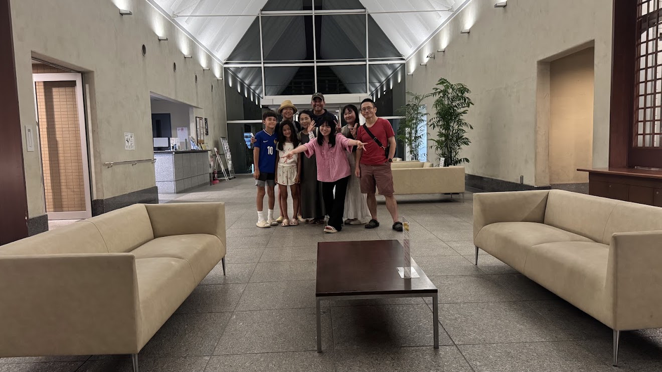 A group of family and friends standing together in a bright lobby with couches