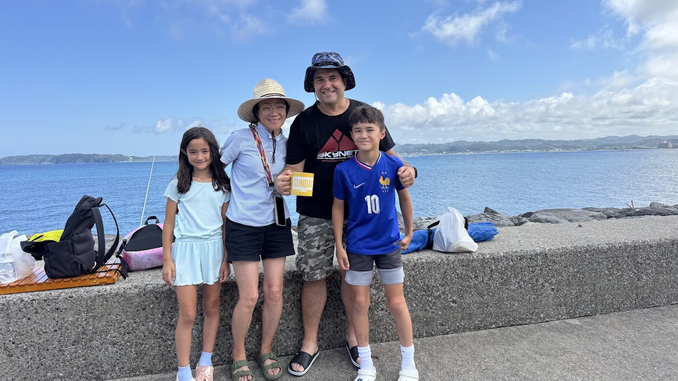 Me, my wife, my son and my daughter standing on a seawall with the ocean behind us on a sunny day