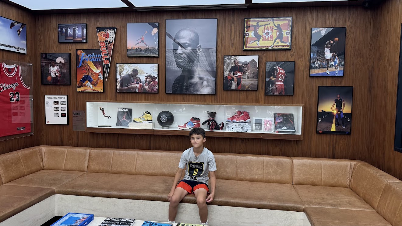 My son sitting in a lounge with walls covered in framed Michael Jordan memorabilia