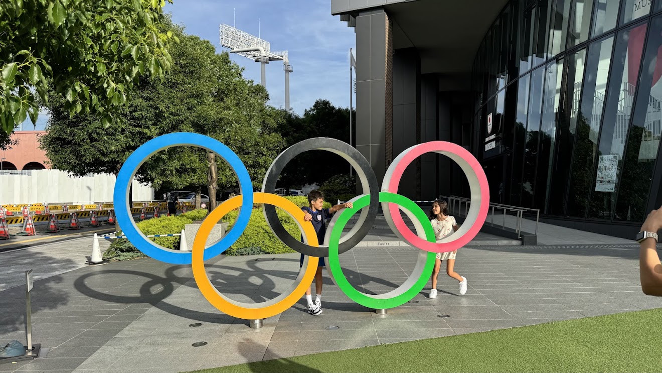 My son and daughter standing inside the giant Olympic rings outside the Japan Olympic Museum in Tokyo